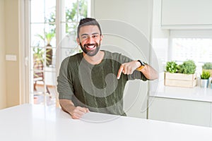 Handsome man pointing with arms and fingers, smiling cheerful with big smile on face