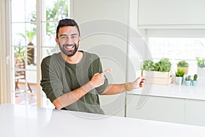 Handsome man pointing with arms and fingers, smiling cheerful with big smile on face