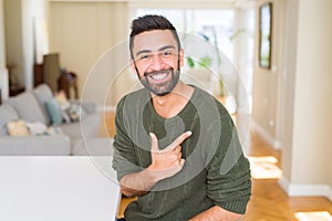 Handsome man pointing with arms and fingers, smiling cheerful with big smile on face
