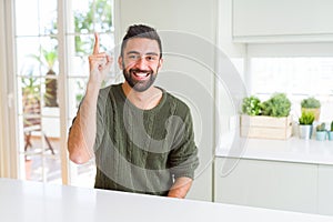 Handsome man pointing with arms and fingers, smiling cheerful with big smile on face