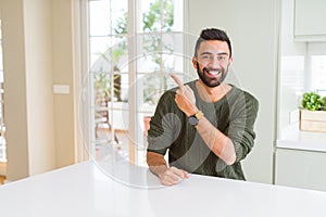 Handsome man pointing with arms and fingers, smiling cheerful with big smile on face