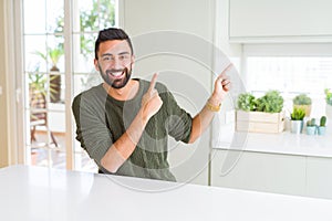 Handsome man pointing with arms and fingers, smiling cheerful with big smile on face