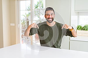 Handsome man pointing with arms and fingers, smiling cheerful with big smile on face