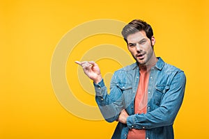 Handsome man pointing with finger and looking at camera Isolated On yellow