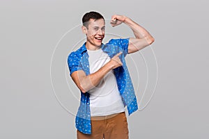 Handsome man pointing at his muscle bicep.