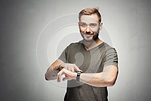 Handsome man pointing at a watch on the wrist