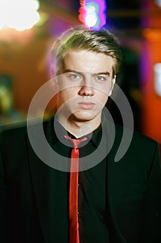 Handsome man portrait in black suit with red tie. Motion blur light effect.