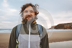 Handsome man portrait curly hair outdoor bearded guy with backpack travel lifestyle