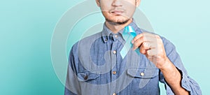 Handsome man posing he holding light blue ribbon for supporting people living