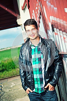 Handsome man posing outdoor over graffiti wall