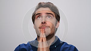 Handsome man praying in studio. Portrait of focused man saying prayer