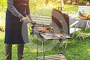 Handsome man preparing barbecue for friend