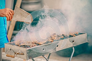 Handsome man preparing barbecue for friends.Hand of senior man grilling some meat.