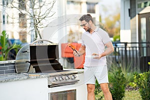 Handsome man preparing barbecue. Male cook cooking meat on barbecue grill. Guy cooking salmon fillet on barbecue for