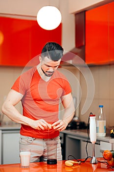 Handsome Man Preparing Protein Shake with Raw Eggs and Banana