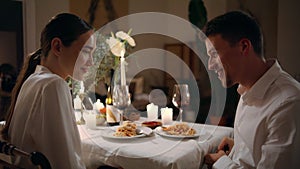 Handsome man proposing marriage to woman at romantic dinner. Guy giving ring