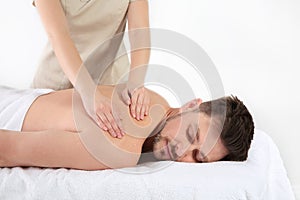 Handsome man receiving back massage on white. Spa service