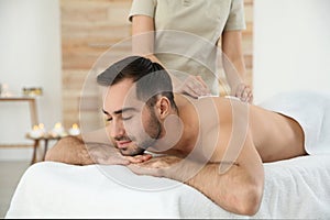 Handsome man receiving hot stone massage