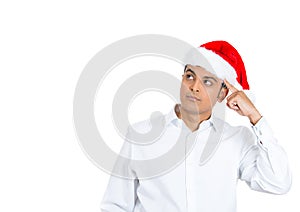 A handsome man in red xmas hat preoccupied and wondering