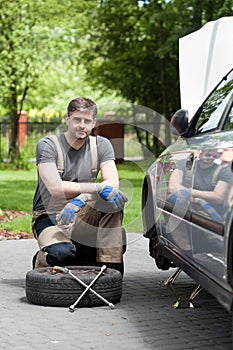 Handsome man repairing car outdoors