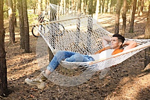 Handsome man resting in hammock outdoors on summer day