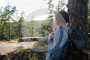 Handsome man resting outdoors at forest, enjoying his vacation.