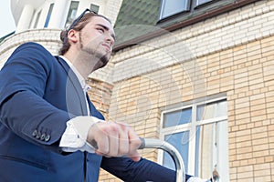 A handsome man rolling his bicycle