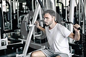 Handsome Man is Rowing Exercise With Bodybuilder Machine in Fitness Club. Sport Man Doing Workout Exercises Calories Burning in