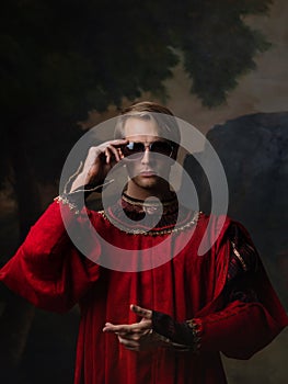 Handsome man in a Royal red doublet and sunglasses.