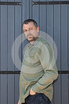 handsome man senior front wooden door outdoor middle age guy in green shirt