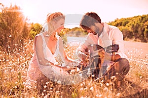 Handsome man serenading his girlfriend with guitar