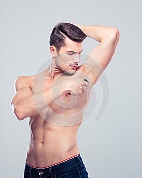 Handsome man shaving his armpit