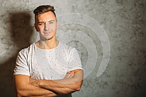 Man in shirt smiling and stand with crossed arms