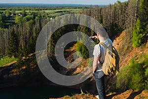 Handsome man shooting selfie in the nautre. Hiking trip. Mountaineering moments. Shooting beautiful views of forest