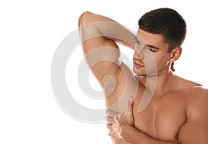Handsome man showing hairy armpit on background. Epilation procedure