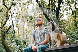 handsome man with siberian husky dog sitting