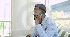 Handsome man sits on couch blab on cell phone