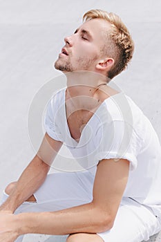 Handsome man sitting in the city on a white background and enjoying