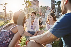 Handsome man sitting with friends laughing outside photo