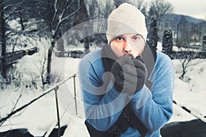 Handsome man sitting outside and freezing photo