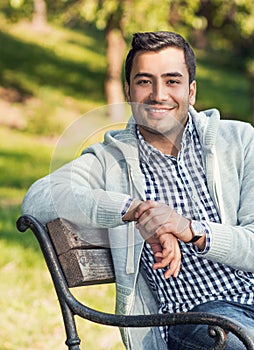 Handsome man sitting in a park photo