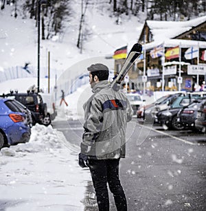 Handsome man with ski walking in snow