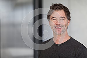 Handsome man smiling at the camera at home