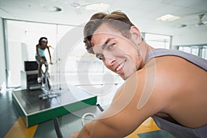 Handsome man smiling at camera in spin class