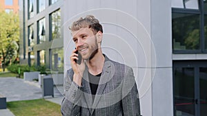 Handsome man Speaking on his Mobile phone calling to business partner outdoor.