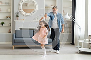 Handsome man spending time at home with his cute little daughter. Happy Father`s Day! Dad and daughter