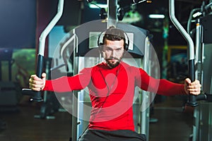 Handsome man in sportswear exercising at gym