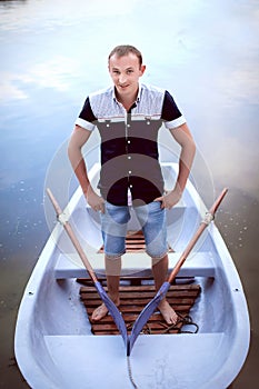Handsome man standing in the boat