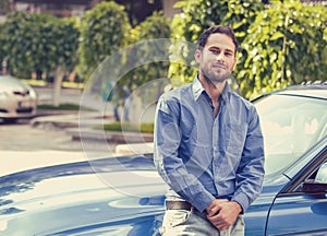 Handsome man standing in front of his car