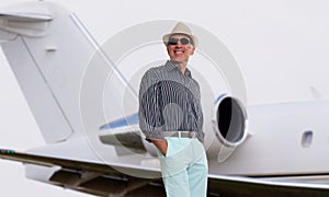 Handsome man standing next to a private jet